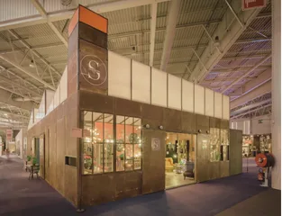 Le stand Signature sur un salon professionnel, façade cuivrée frappée du monogramme S